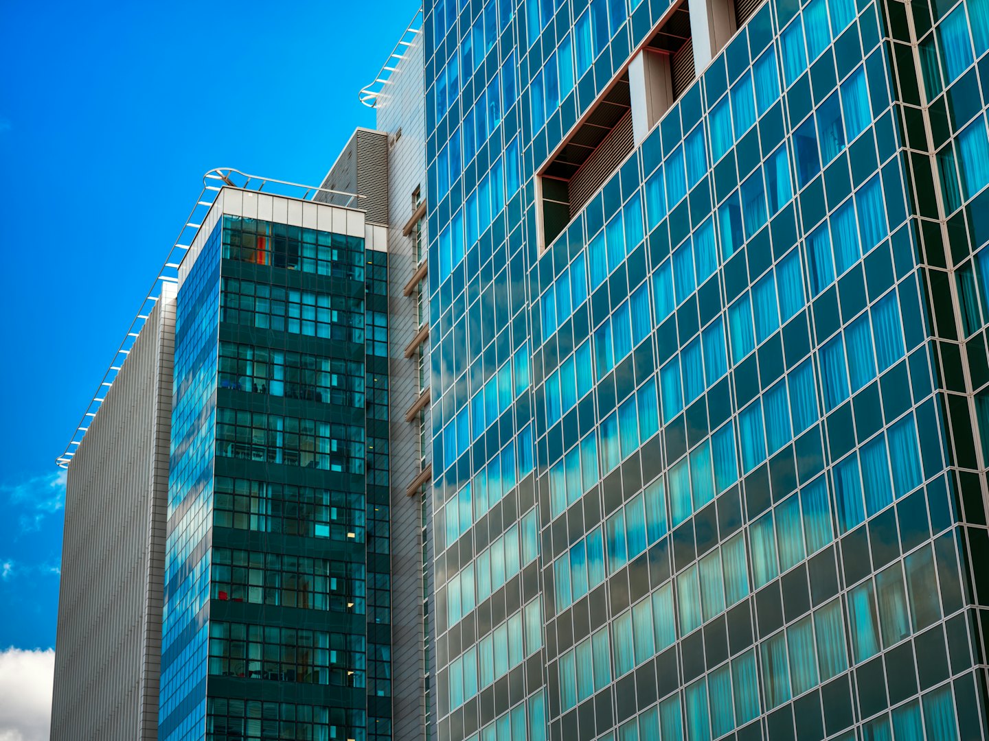 Two modern glass skyscrapers reach toward the blue sky.